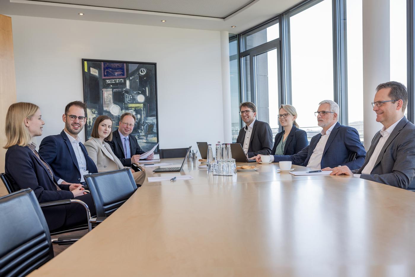 Eine Gruppe aus Anwälte unterhalten sich in an einem Konferenztisch