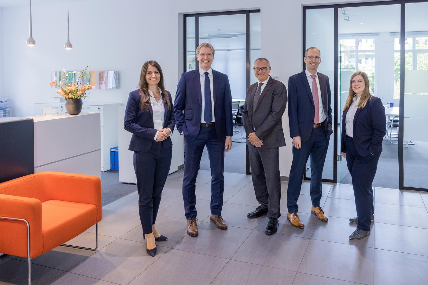 5 Anwälte lächeln und schauen in Richtung des Betrachters